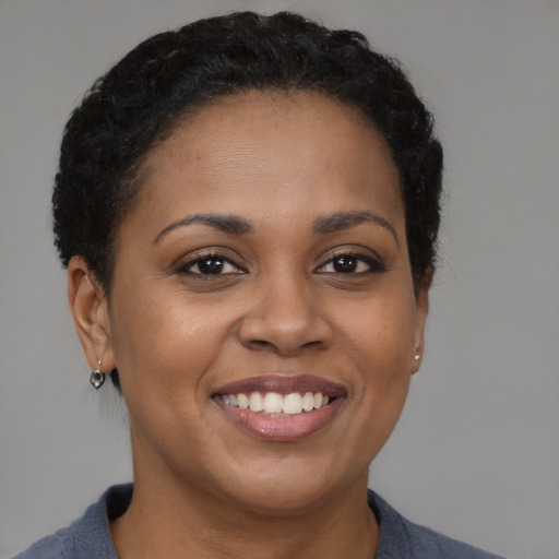 Joyful black adult female with short  brown hair and brown eyes