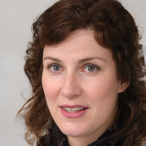 Joyful white young-adult female with medium  brown hair and green eyes