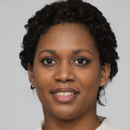 Joyful black young-adult female with short  black hair and brown eyes