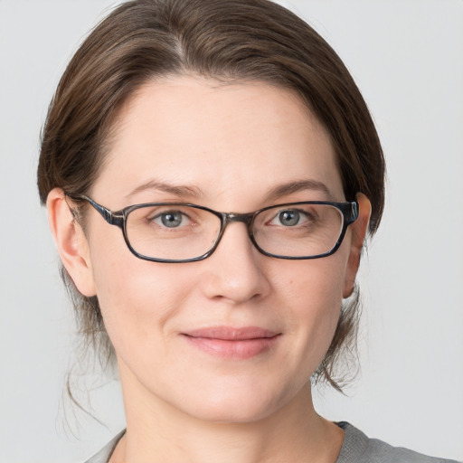 Joyful white young-adult female with medium  brown hair and grey eyes