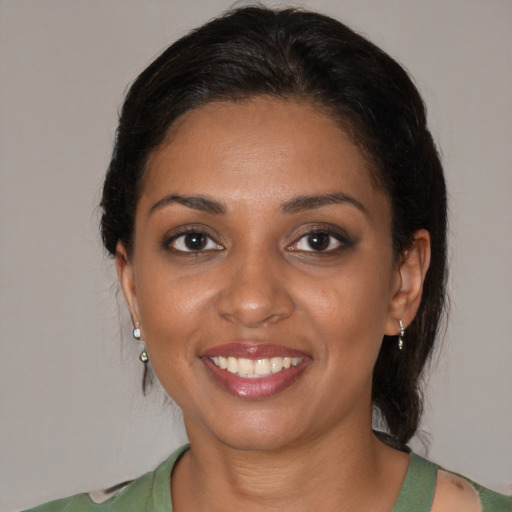 Joyful black young-adult female with medium  brown hair and brown eyes