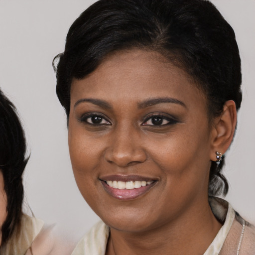 Joyful black young-adult female with medium  brown hair and brown eyes