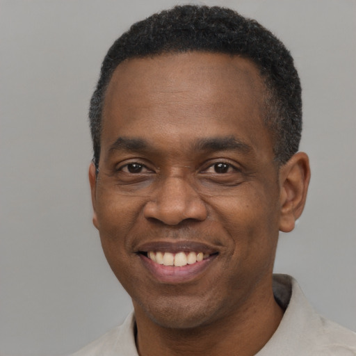 Joyful black adult male with short  black hair and brown eyes