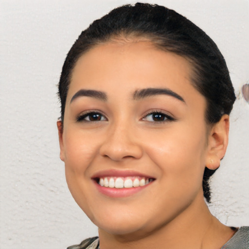 Joyful latino young-adult female with short  black hair and brown eyes