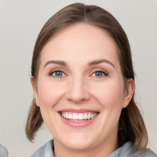 Joyful white young-adult female with medium  brown hair and blue eyes