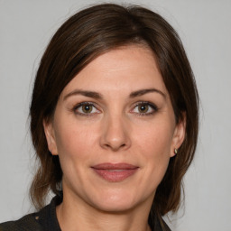 Joyful white adult female with medium  brown hair and brown eyes