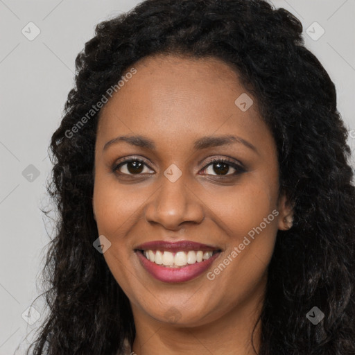 Joyful black young-adult female with long  brown hair and brown eyes