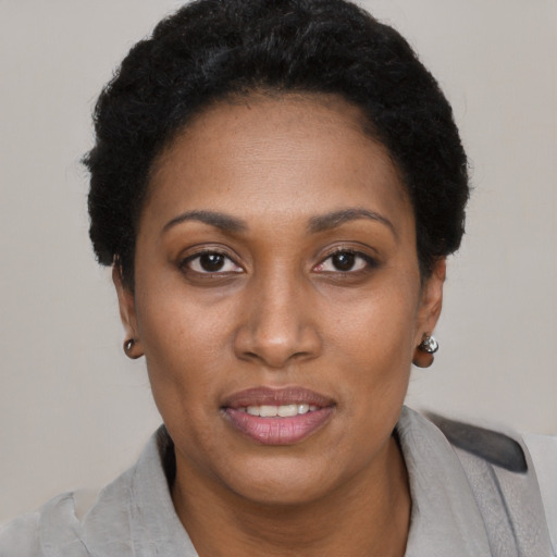 Joyful black adult female with short  black hair and brown eyes
