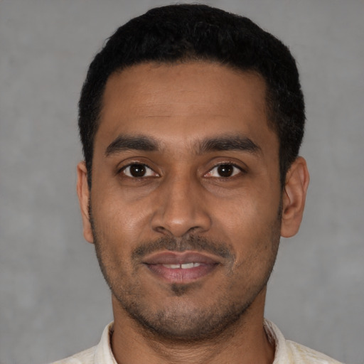 Joyful latino young-adult male with short  black hair and brown eyes
