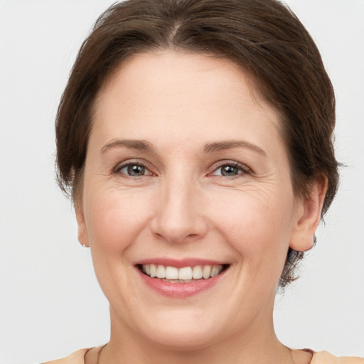 Joyful white adult female with medium  brown hair and grey eyes