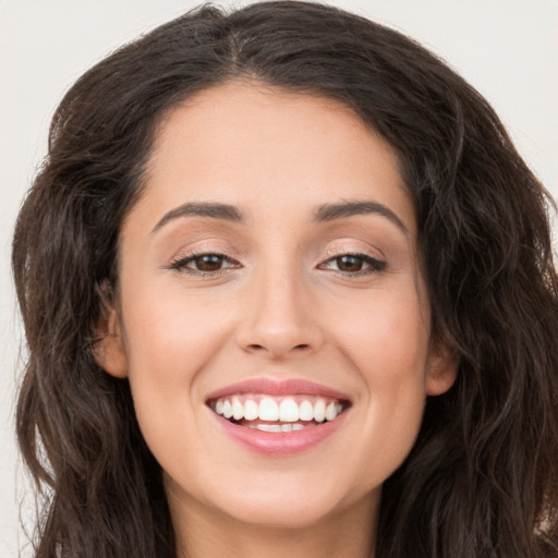 Joyful white young-adult female with long  brown hair and brown eyes