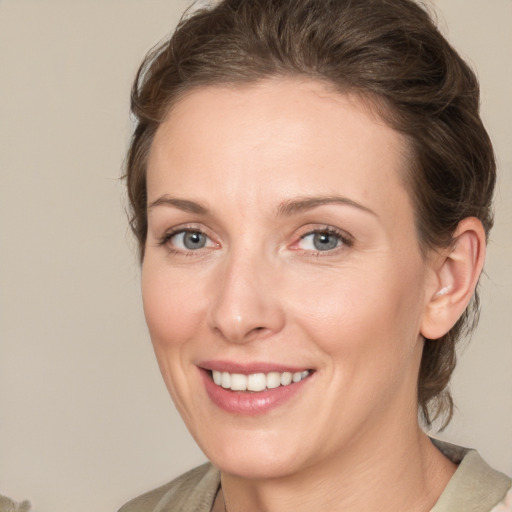 Joyful white young-adult female with medium  brown hair and grey eyes