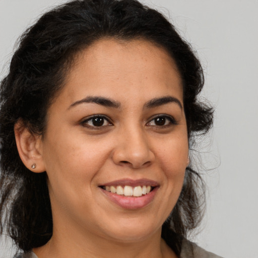 Joyful latino young-adult female with medium  brown hair and brown eyes