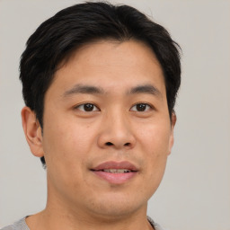 Joyful asian young-adult male with short  brown hair and brown eyes