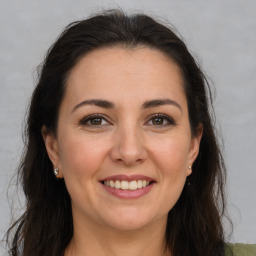 Joyful white adult female with long  brown hair and brown eyes