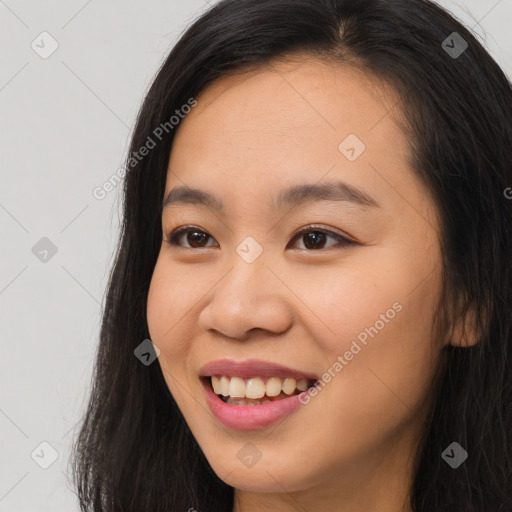 Joyful asian young-adult female with long  brown hair and brown eyes