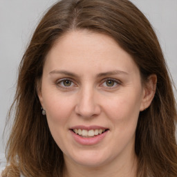 Joyful white young-adult female with long  brown hair and grey eyes