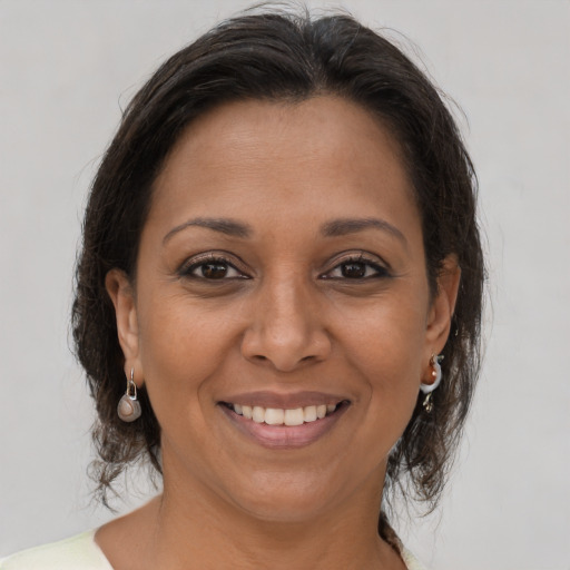 Joyful latino adult female with medium  brown hair and brown eyes