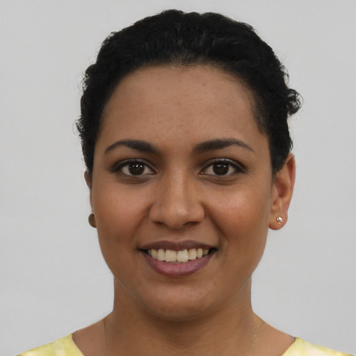 Joyful latino young-adult female with short  black hair and brown eyes