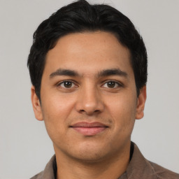 Joyful latino young-adult male with short  black hair and brown eyes