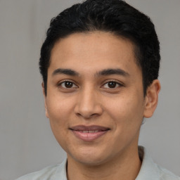 Joyful latino young-adult male with short  black hair and brown eyes