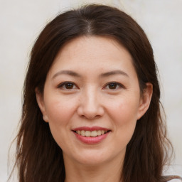 Joyful white adult female with long  brown hair and brown eyes