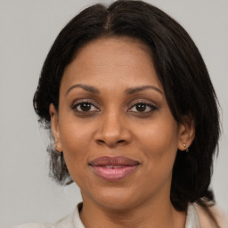 Joyful black adult female with medium  brown hair and brown eyes