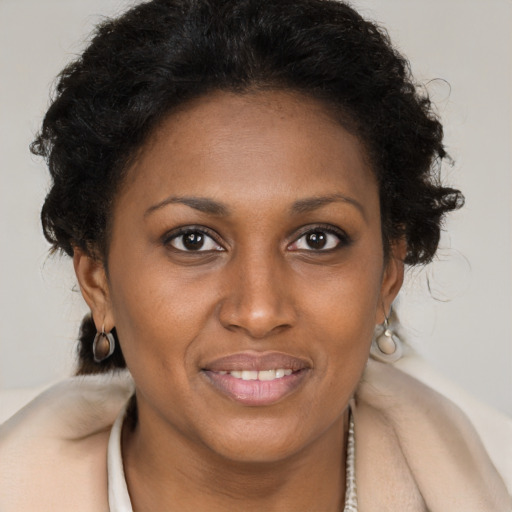 Joyful black adult female with long  brown hair and brown eyes