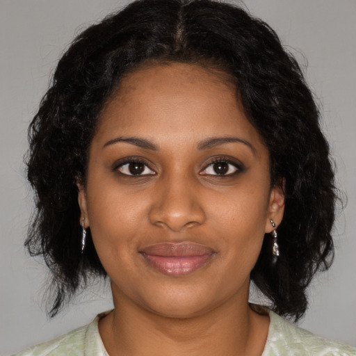 Joyful black young-adult female with medium  brown hair and brown eyes