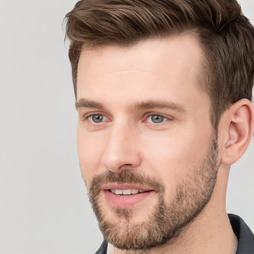 Joyful white young-adult male with short  brown hair and grey eyes