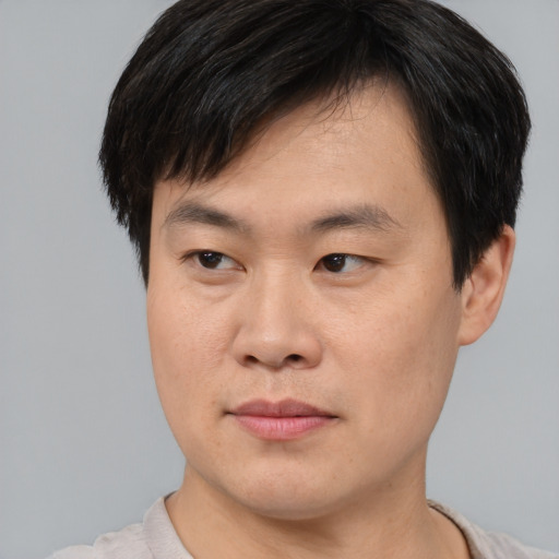 Joyful asian young-adult male with short  brown hair and brown eyes