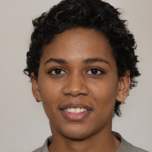 Joyful black young-adult female with short  black hair and brown eyes