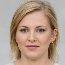 Joyful white young-adult female with medium  brown hair and green eyes