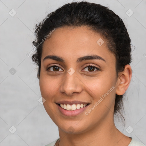 Joyful latino young-adult female with medium  brown hair and brown eyes