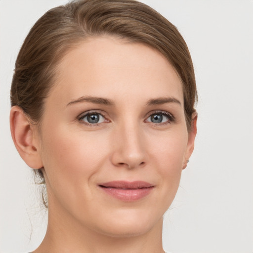 Joyful white young-adult female with medium  brown hair and grey eyes