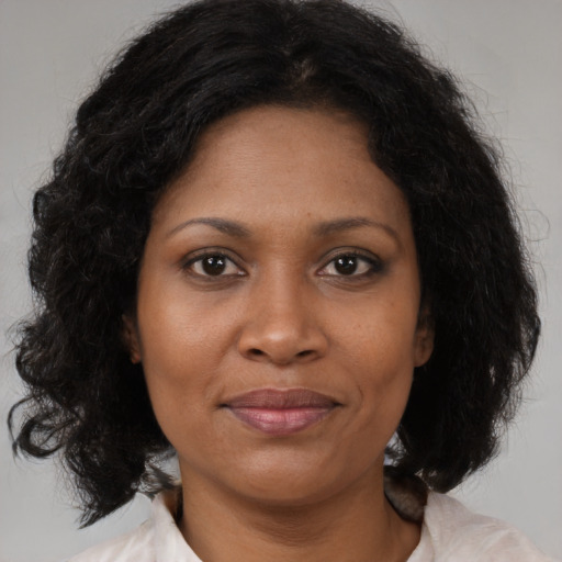 Joyful black adult female with medium  brown hair and brown eyes