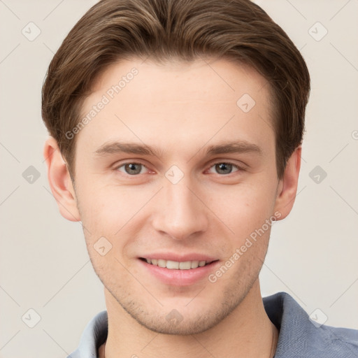 Joyful white young-adult male with short  brown hair and grey eyes