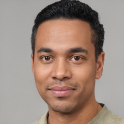 Joyful latino young-adult male with short  black hair and brown eyes