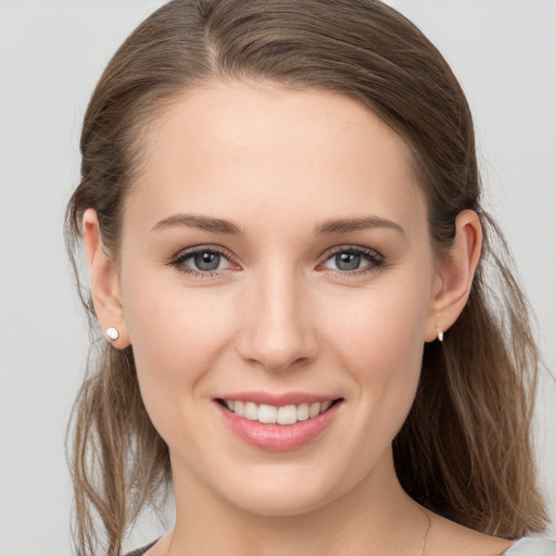 Joyful white young-adult female with medium  brown hair and grey eyes