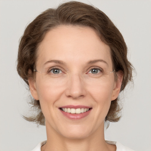 Joyful white adult female with medium  brown hair and grey eyes