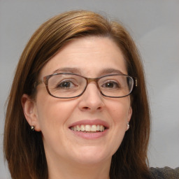 Joyful white adult female with medium  brown hair and blue eyes