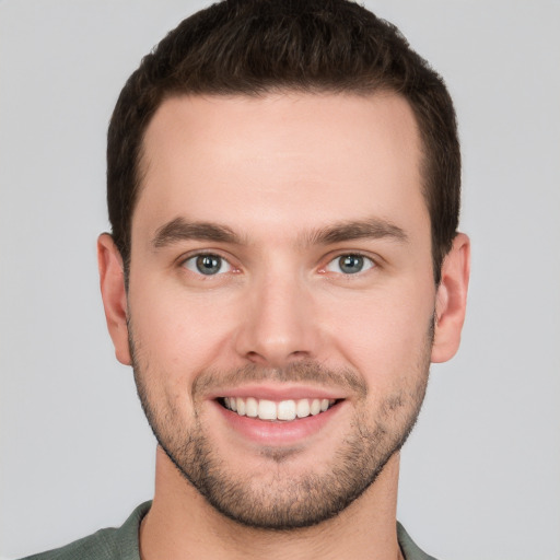 Joyful white young-adult male with short  brown hair and grey eyes