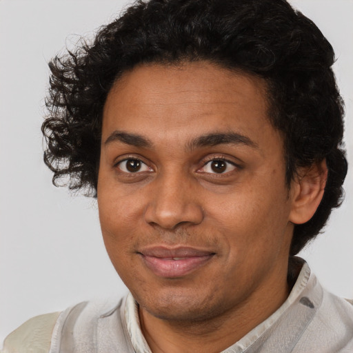 Joyful black young-adult male with short  brown hair and brown eyes