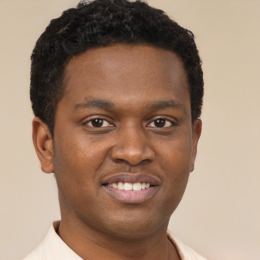 Joyful black young-adult male with short  brown hair and brown eyes