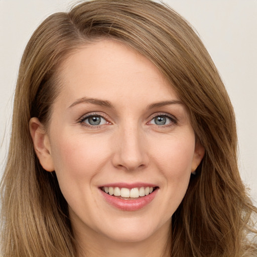 Joyful white young-adult female with long  brown hair and blue eyes