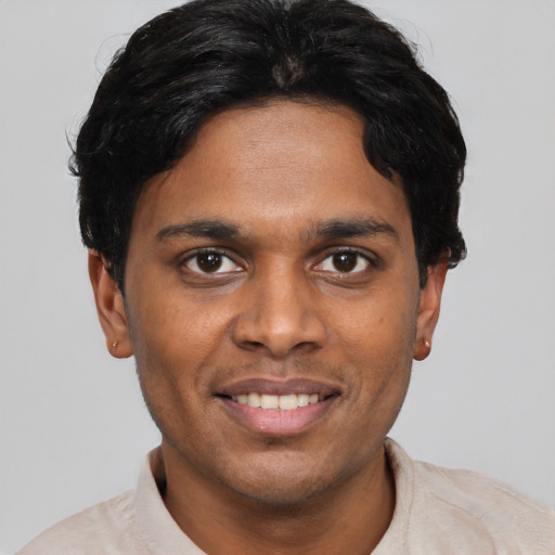 Joyful black young-adult male with short  brown hair and brown eyes