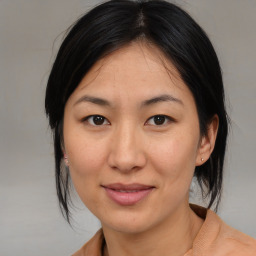 Joyful asian adult female with medium  brown hair and brown eyes