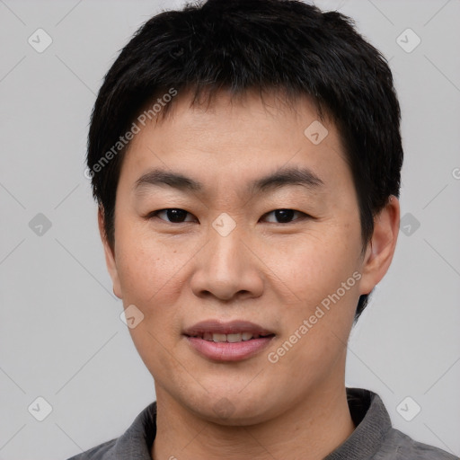 Joyful asian young-adult male with short  black hair and brown eyes