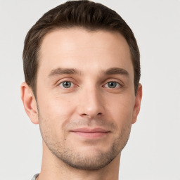 Joyful white young-adult male with short  brown hair and grey eyes