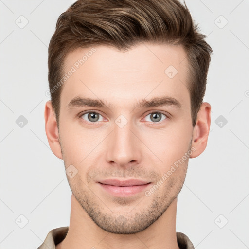 Joyful white young-adult male with short  brown hair and grey eyes